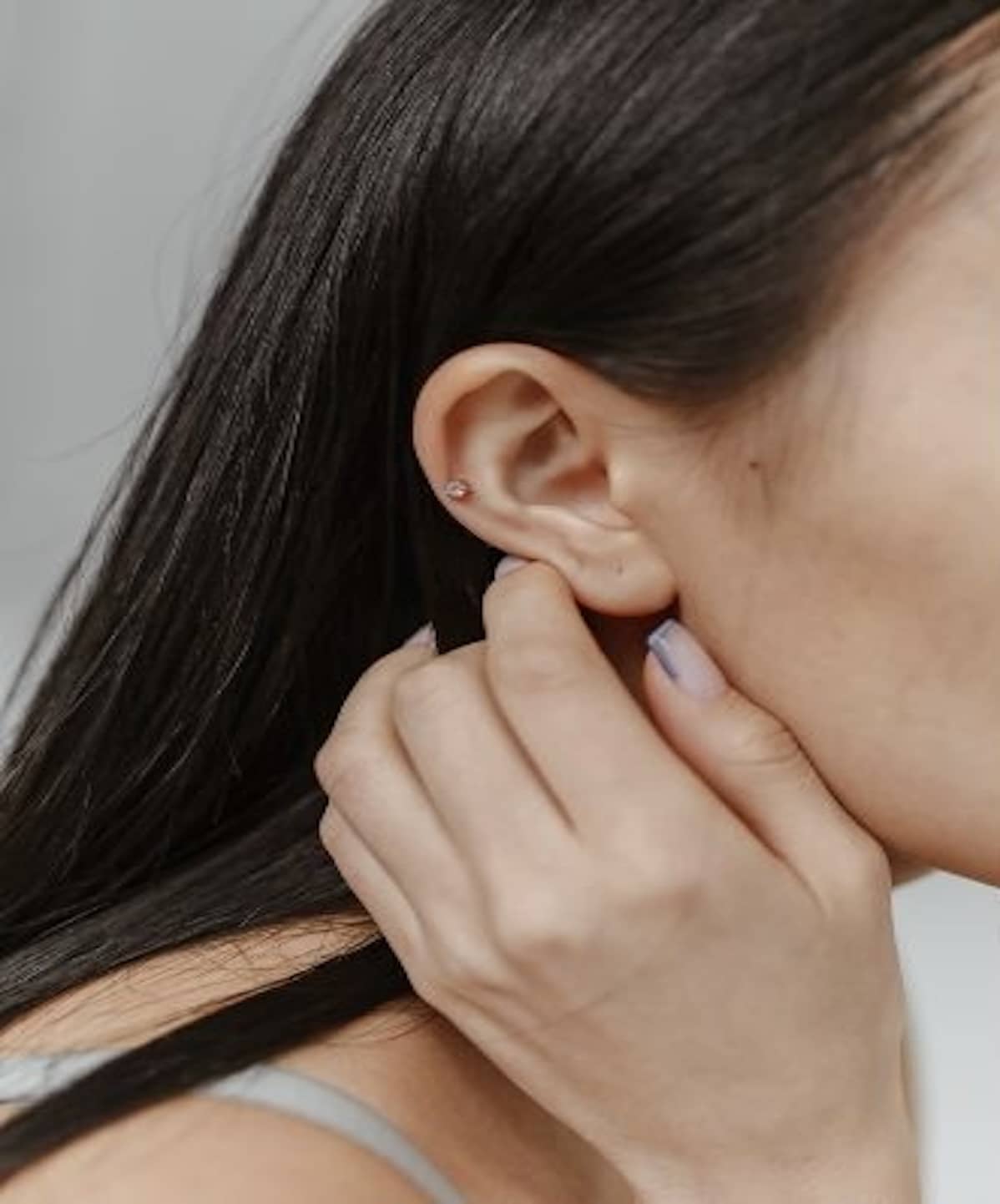 girl holding ear